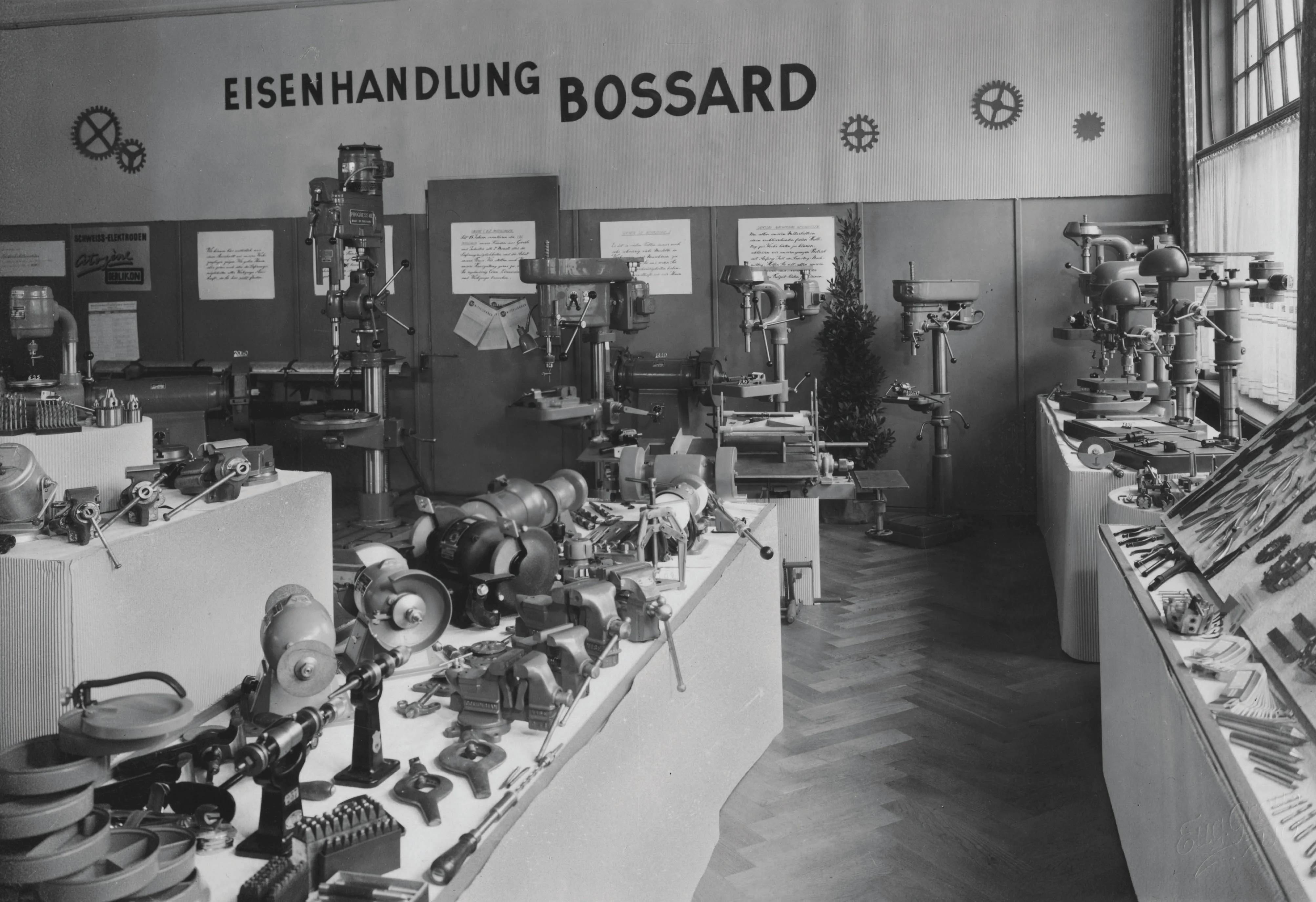一张1930年代Bossard五金店的黑白老照片，店内摆满了各种工具和设备。