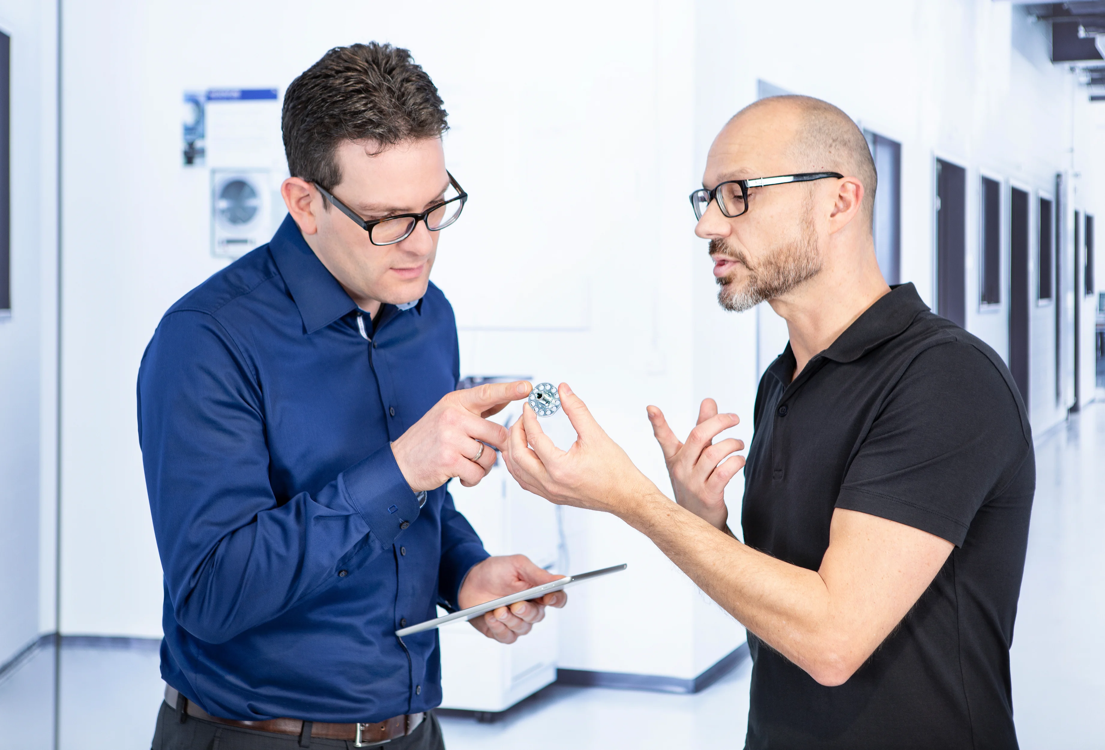 Two people discussing design of a fastener.